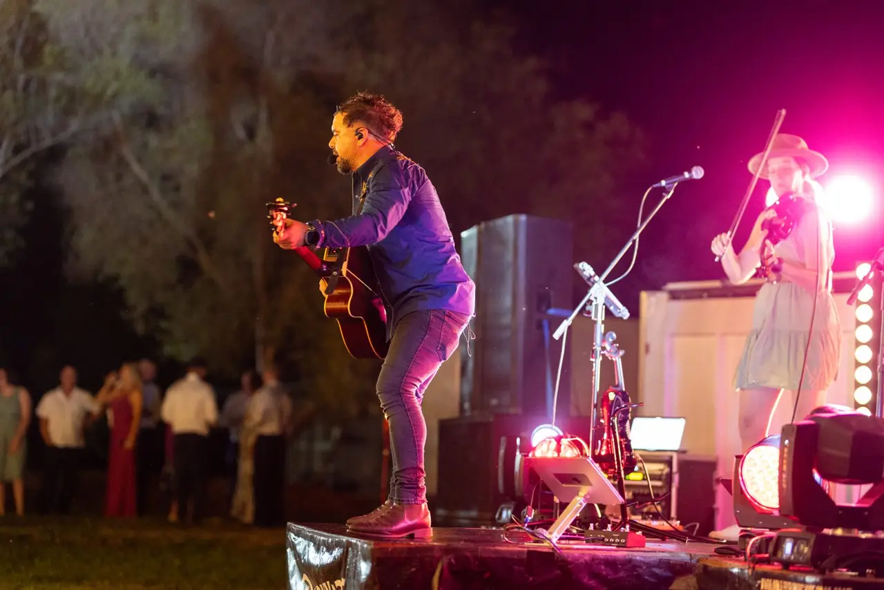 The Barnyard Band live on an outdoor stage at night