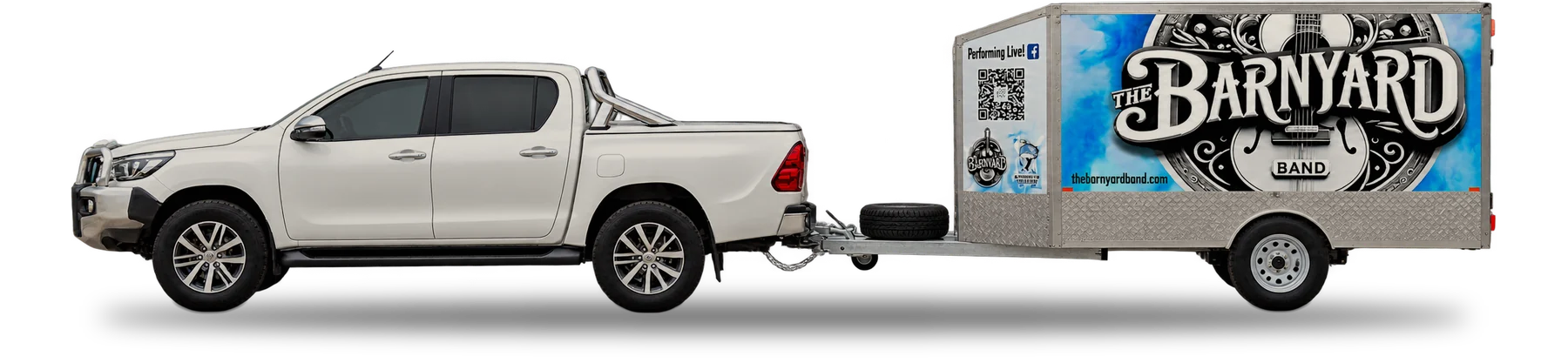 The Barnyard Band Hilux towing the branded trailer, side view